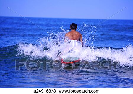 Man surfing on the sea with spray around View Large Photo Image Stock Photo - Man surfing on the sea with spray around. Fotosearch