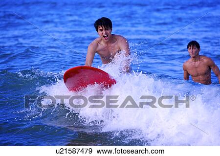 Man teaching young man surfing on the sea View Large Photo Image Stock Photo - Man teaching young man surfing on the sea. Fotosearch