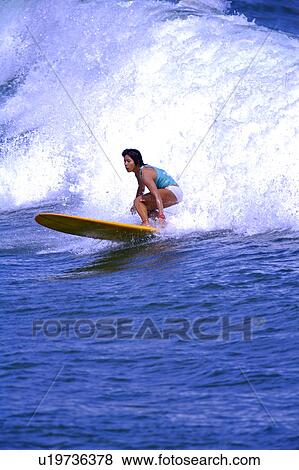 Woman surfing on the sea skillfully with surf behind View Large Photo Image Stock Photo - Woman surfing on the sea skillfully with surf behind. Fotosearch