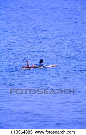 Young woman floating on the sea with the surfboard View Large Photo Image Stock Image - Young woman floating on the sea with the surfboard. Fotosearch