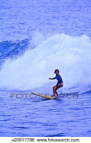 Young woman surfing on the sea skillfully with huge surf behind View Large Photo Image Stock Photograph - Young woman surfing on the sea skillfully with huge surf behind. Fotosearch