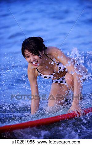 Young woman surfing on the sea with spray around View Large Photo Image Stock Photography - Young woman surfing on the sea with spray around. Fotosearch