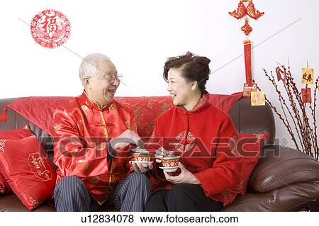 Elderly couple in traditional clothes holding tea cup and smiling at each other View Large Photo Image Stock Photo - Elderly couple in traditional clothes holding tea cup and smiling at each other. Fotosearch