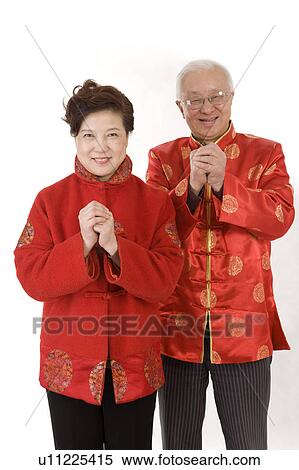 Elderly couple in traditional clothes smiling at the camera with hands clasped View Large Photo Image Stock Photography - Elderly couple in traditional clothes smiling at the camera with hands clasped. Fotosearch