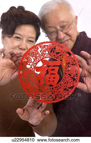 Stock Image - Elderly couple looking at the decoupage. Fotosearch