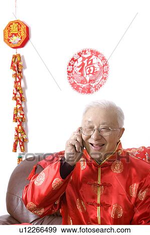 Elderly man in traditional clothes smiling happily, on the phone View Large Photo Image Stock Photo - Elderly man in traditional clothes smiling happily, on the phone. Fotosearch
