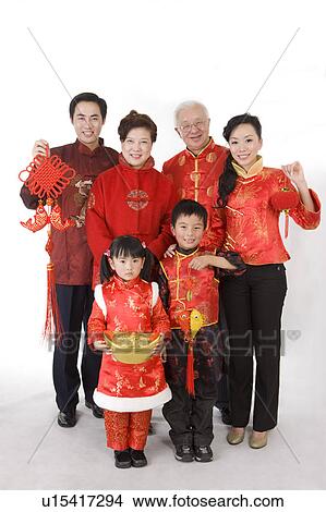 Picture - Family members in traditional clothes holding Chinese decorations and smiling at the camera. Fotosearch