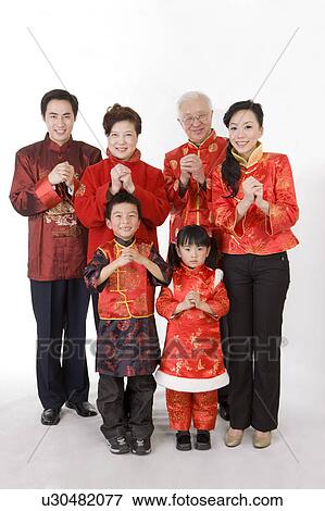 Family members in traditional clothes smiling at the camera with hands clasped View Large Photo Image Stock Photo - Family members in traditional clothes smiling at the camera with hands clasped. Fotosearch