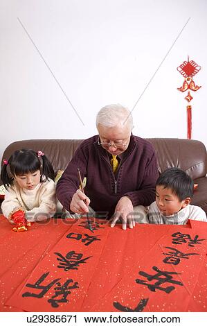 Senior man writing calligraphy on couplets with two children watching View Large Photo Image Stock Image - Senior man writing calligraphy on couplets with two children watching. Fotosearch