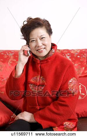 Senior woman in traditional clothes smiling at the camera, on the phone View Large Photo Image Stock Image - Senior woman in traditional clothes smiling at the camera, on the phone. Fotosearch