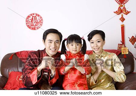 Young family with one child in traditional clothes smiling at the camera with hands clasped View Large Photo Image Stock Photography - Young family with one child in traditional clothes smiling at the camera with hands clasped. Fotosearch