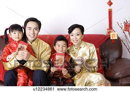Young family with two children in traditional clothes holding red envelopes and smiling at the camera View Large Photo Image Stock Image - Young family with two children in traditional clothes holding red envelopes and smiling at the camera. Fotosearch
