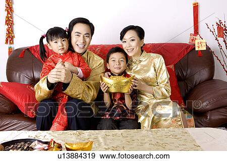 Young family with two children in traditional clothes smiling at the camera and celebrating Chinese New Year View Large Photo Image Stock Photo - Young family with two children in traditional clothes smiling at the camera and celebrating Chinese New Year. Fotosearch