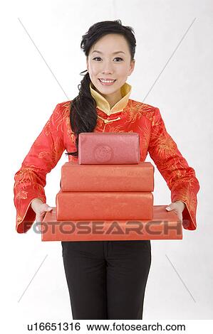 Young woman in traditional clothes holding gifts and smiling at the camera View Large Photo Image Stock Photograph - Young woman in traditional clothes holding gifts and smiling at the camera. Fotosearch