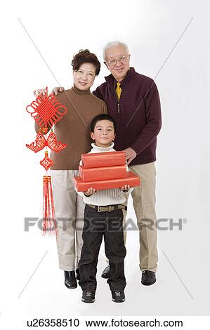 Elderly couple with little boy holding a tassel and gifts, smiling at the camera View Large Photo Image Stock Image - Elderly couple with little boy holding a tassel and gifts, smiling at the camera. Fotosearch