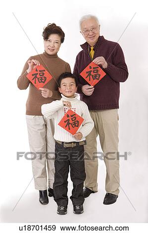 Elderly couple with little boy holding Chinese scripts and smiling at the camera View Large Photo Image Stock Photo - Elderly couple with little boy holding Chinese scripts and smiling at the camera. Fotosearch