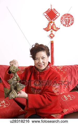Elderly woman in traditional clothes holding Chinese rice dumplings and smiling at the camera View Large Photo Image Stock Photograph - Elderly woman in traditional clothes holding Chinese rice dumplings and smiling at the camera. Fotosearch