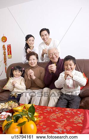 Stock Image - Family members smiling at the camera with hands clasped. Fotosearch