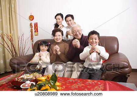 Family members smiling at the camera with hands clasped View Large Photo Image Stock Photo - Family members smiling at the camera with hands clasped. Fotosearch