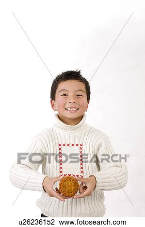 Little boy holding a moon cake and smiling at the camera View Large Photo Image Stock Image - Little boy holding a moon cake and smiling at the camera. Fotosearch