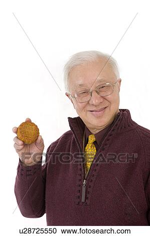 Senior man holding a moon cake and smiling at the camera View Large Photo Image Stock Image - Senior man holding a moon cake and smiling at the camera. Fotosearch