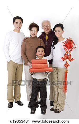The whole family holding gifts and an New Year Ornament, looking at the camera together View Large Photo Image Picture - The whole family holding gifts and an New Year Ornament, looking at the camera together. Fotosearch