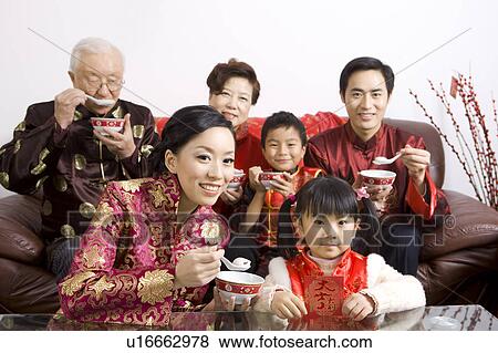 The whole family in traditional clothes eating dumplings and looking at the camera View Large Photo Image Stock Photo - The whole family in traditional clothes eating dumplings and looking at the camera. Fotosearch