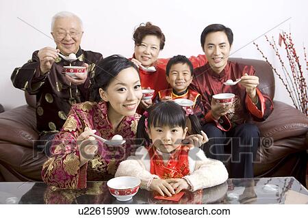 The whole family member in traditional clothing eating stuffed dumpling and smiling at the camera together View Large Photo Image Stock Photo - The whole family member in traditional clothing eating stuffed dumpling and smiling at the camera together. Fotosearch