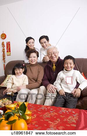 The whole family sitting on the sofa and smiling at the camera View Large Photo Image Stock Photo - The whole family sitting on the sofa and smiling at the camera. Fotosearch