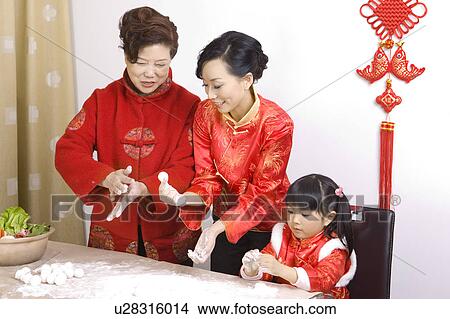 Picture - Two women and a little girl making stuffed dumplings together. Fotosearch
