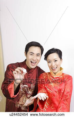 Young couple in traditional clothes holding stuffed dumplings and smiling happily at the camera View Large Photo Image Picture - Young couple in traditional clothes holding stuffed dumplings and smiling happily at the camera. Fotosearch