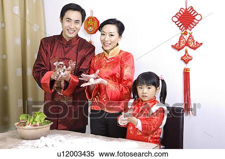 Young couple with one child making stufffed dumplings together and looking at the camera View Large Photo Image Stock Photography - Young couple with one child making stufffed dumplings together and looking at the camera. Fotosearch