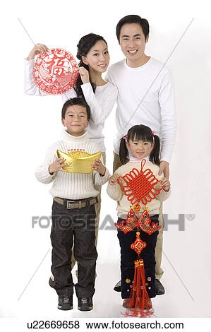Young family with two children holding the decorations to celebrating Chinese New Year and looking at the camera View Large Photo Image Stock Photo - Young family with two children holding the decorations to celebrating Chinese New Year and looking at the camera. Fotosearch