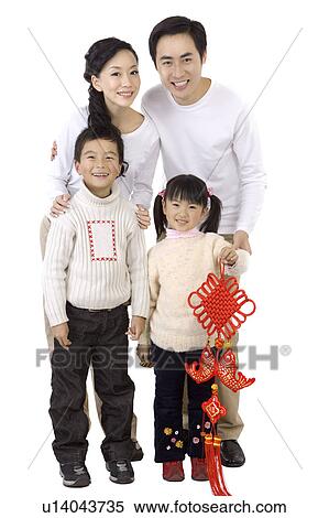 Stock Photography - Young family with two children holding a tassel and smiling at the camera.. Fotosearch