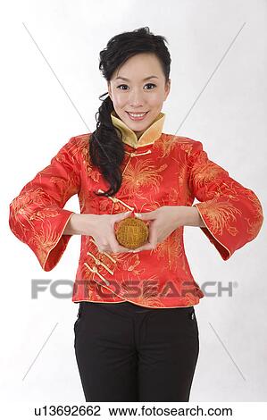 Young woman in traditional clothing holding a moon cake and smiling at the camera View Large Photo Image Stock Image - Young woman in traditional clothing holding a moon cake and smiling at the camera. Fotosearch