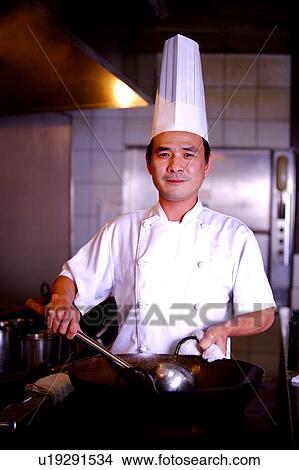 Chef holding the pan and spatula, looking at the camera View Large Photo Image Picture - Chef holding the pan and spatula, looking at the camera. Fotosearch
