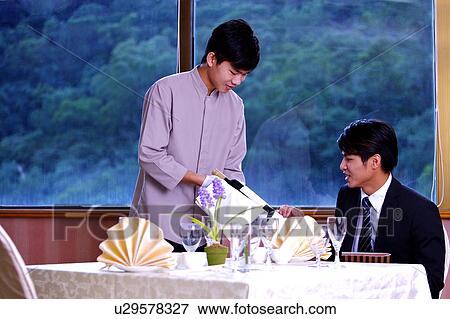 Waiter showing a bottle of red wine to young man View Large Photo Image Stock Photo - Waiter showing a bottle of red wine to young man. Fotosearch