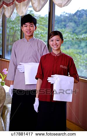 Young waiter and waitress holding the towel and smiling at the camera View Large Photo Image Stock Photo - Young waiter and waitress holding the towel and smiling at the camera. Fotosearch