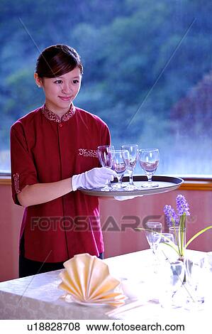 Young waitress holding a tray with wine glasses and smiling View Large Photo Image Stock Photo - Young waitress holding a tray with wine glasses and smiling. Fotosearch