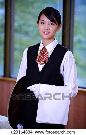 Young waitress holding the tray and towel, smiling at the camera View Large Photo Image Picture - Young waitress holding the tray and towel, smiling at the camera. Fotosearch