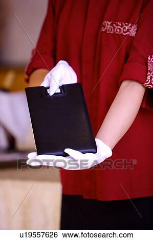 Stock Photograph - Young waitress showing the menu. Fotosearch