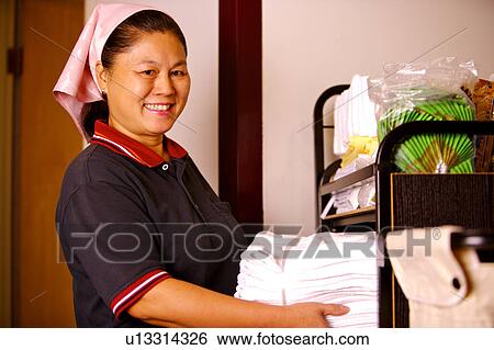 Waitress holding a stack of folded towels and smiling at the camera View Large Photo Image Stock Photograph - Waitress holding a stack of folded towels and smiling at the camera. Fotosearch