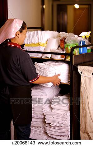 Waitress putting a stack of folded towels into cleaning equipment View Large Photo Image Stock Image - Waitress putting a stack of folded towels into cleaning equipment. Fotosearch