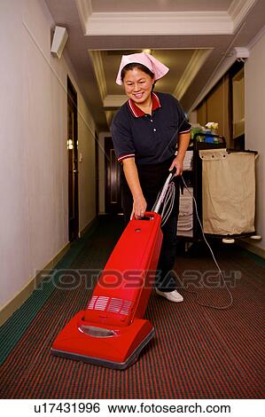 Stock Photograph - Waitress using cleaner to clean the floor of hotel. Fotosearch
