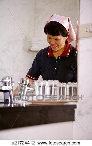 Waitress washing glass and smiling View Large Photo Image Stock Image - Waitress washing glass and smiling. Fotosearch