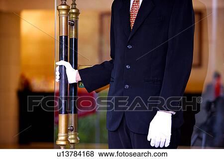 Stock Photo - Young man holding the handle of the door. Fotosearch