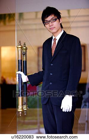 Young waiter pulling the door and looking at the camera View Large Photo Image Stock Image - Young waiter pulling the door and looking at the camera. Fotosearch
