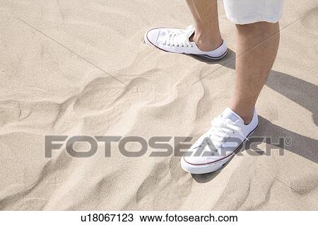 Stock Image - Foot of man on a beach. Fotosearch