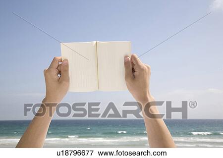Stock Photo - Hands holding up a book. Fotosearch