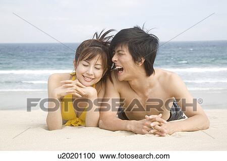 Japanese couple lying on a beach in swimsuit View Large Photo Image Stock Image - Japanese couple lying on a beach in swimsuit. Fotosearch